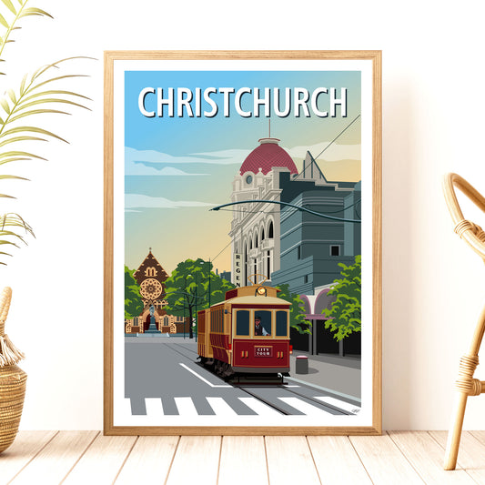 A framed travel poster of Christchurch, New Zealand, featuring a vibrant illustration of the cityscape with a prominent red tram and historical buildings.
