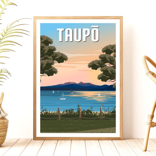 A framed travel poster depicting a scenic view of Lake Taupā and the surrounding mountains at sunset, with the word 'TAUPO' written at the top.