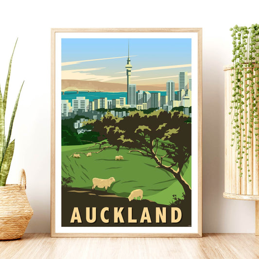 A framed travel poster of Auckland, New Zealand, featuring a volcanic crater, city skyline with the Sky Tower, and Harbour Bridge.