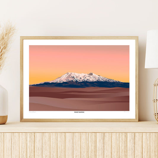 Framed artwork of a mountain landscape with a warm color palette on a wall.